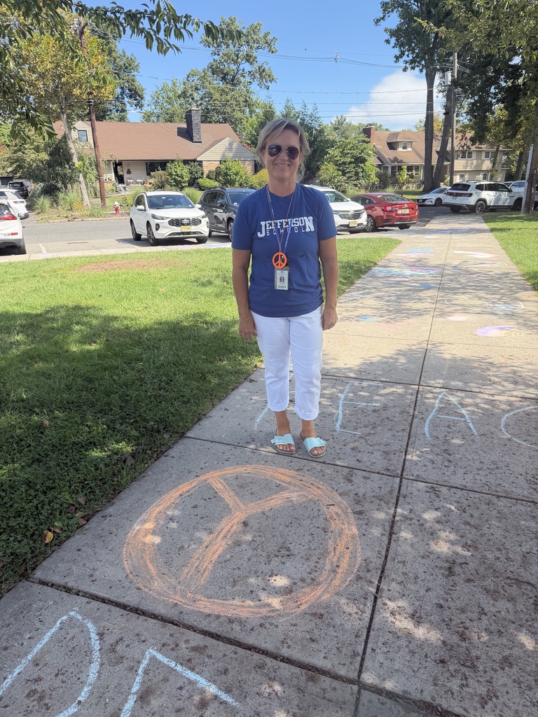 Teacher stands with the peace sign