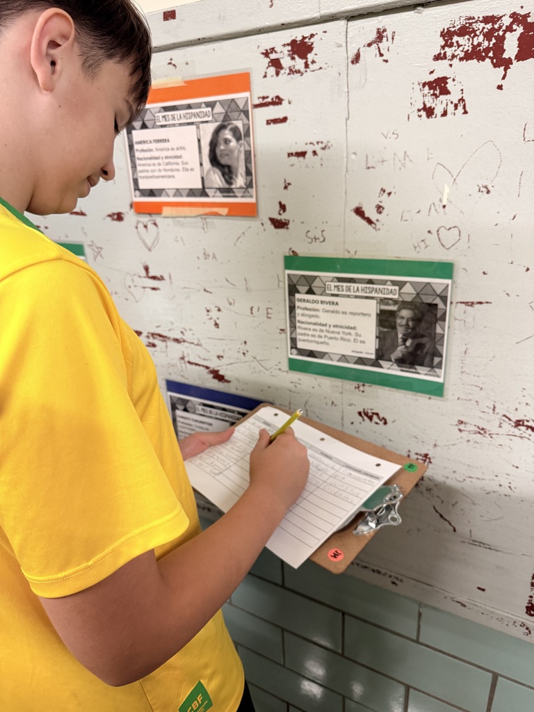student writing on a clipboard