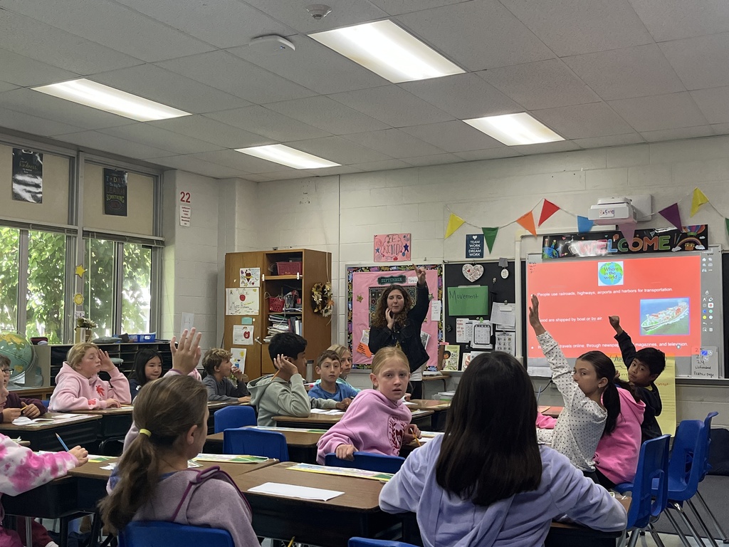 Students raising their hands to volunteer to participate.