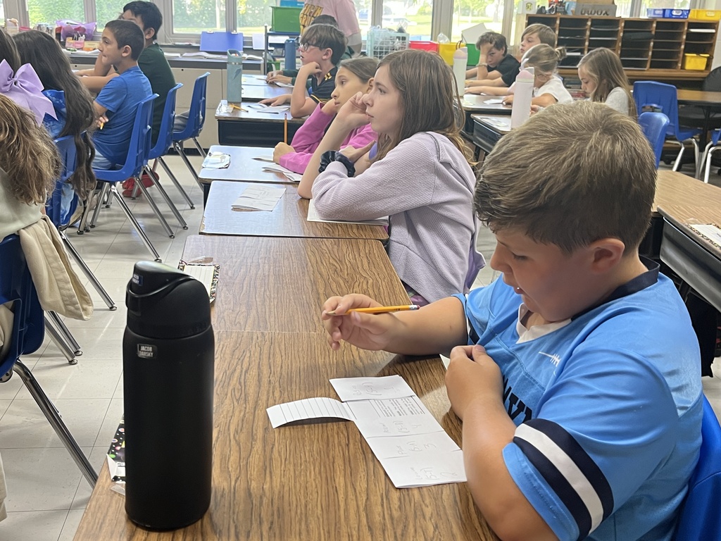 Students sitting and listening to the teacher.
