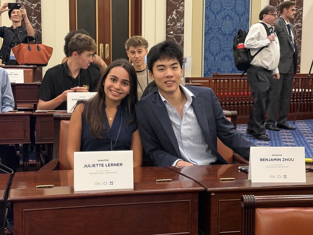 Westfield students Juliette Lerner and Benjamin Zhou smile together at a Senate desk, identified by name cards reading "SENATOR JULIETTE LERNER" and "SENATOR BENJAMIN ZHOU."