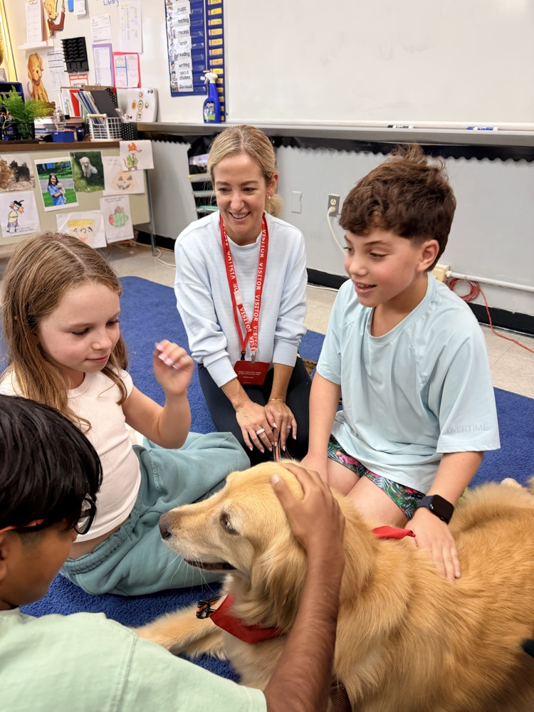 students enjoy a visit from a therapy dog
