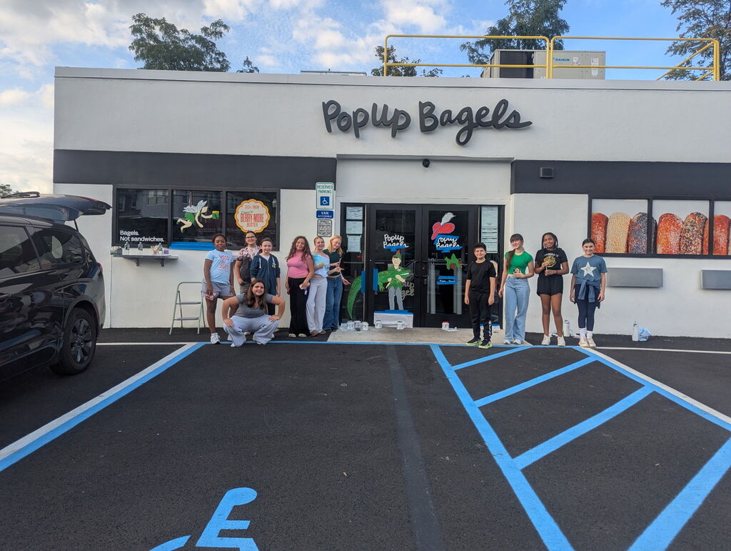 students posing in front of a storefront