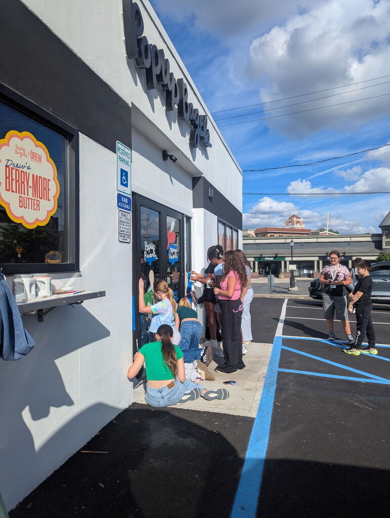 students painting a storefront