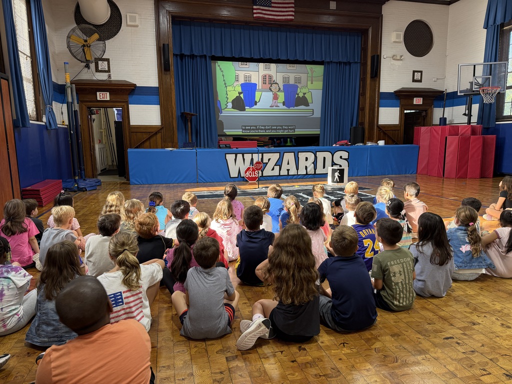 second grade students sitting on the floor watching a pedestrian safety video