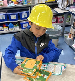 a first grade student, sitting at their desk reading
