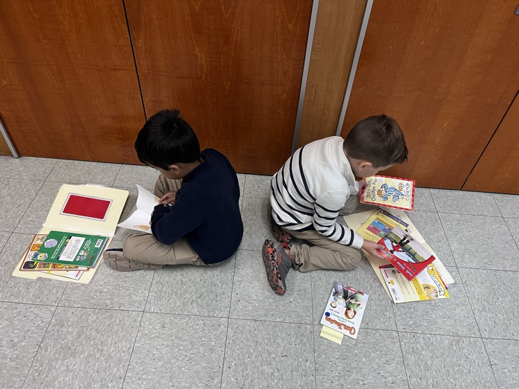  students reading in pairs on the carpet 