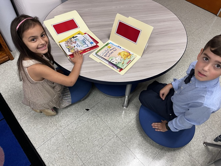  students reading in pairs on the carpet 