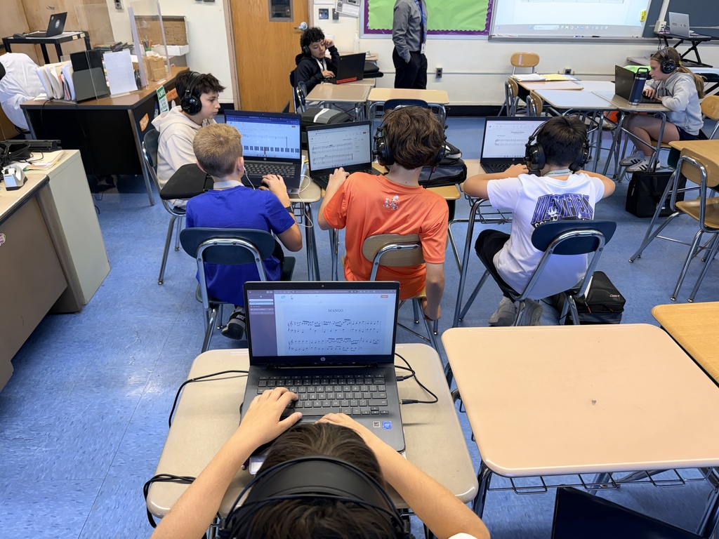students at Chromebooks wearing headphones