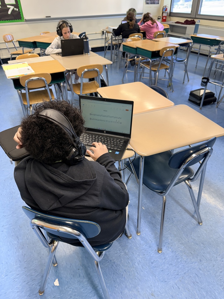 students at Chromebooks wearing headphones