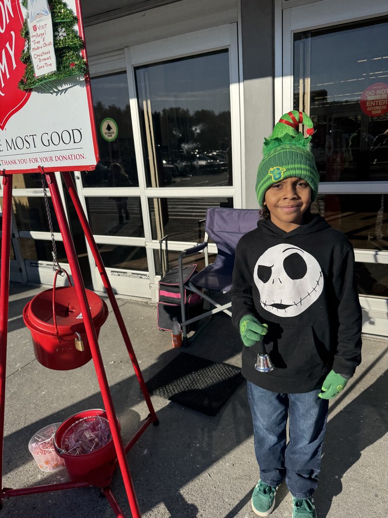 One student pictured next to the salvation army donation bucket, helping raise money.
