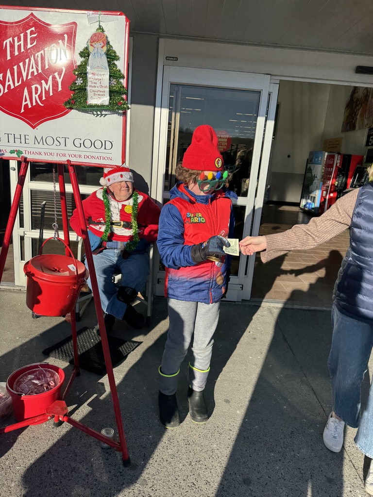 A student receiving a donation for the salvation army . 