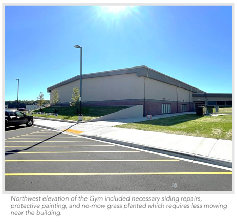 Northwest elevation of the gym included necessary siding repairs, protective painting, and no-mow grass planted to minimize mowing near the building.
