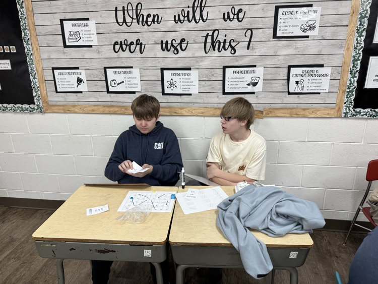 Algebra students are having fun reviewing slope and linear equations with a board game.