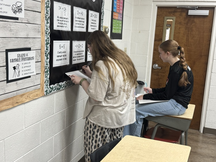 Algebra students are reviewing exponent rules with a scavenger hunt.
