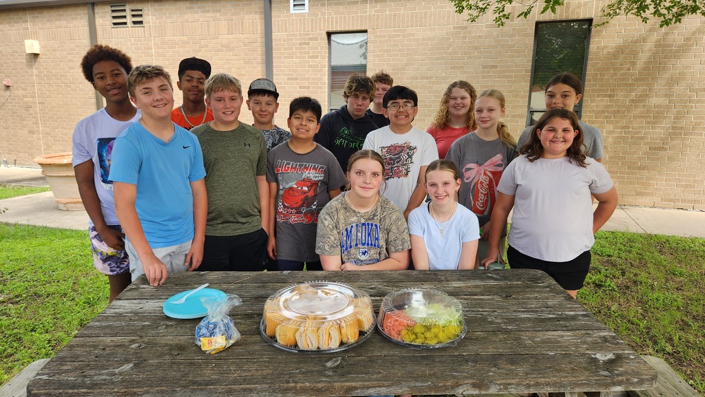 students outside at picnic table with a sandwich tray