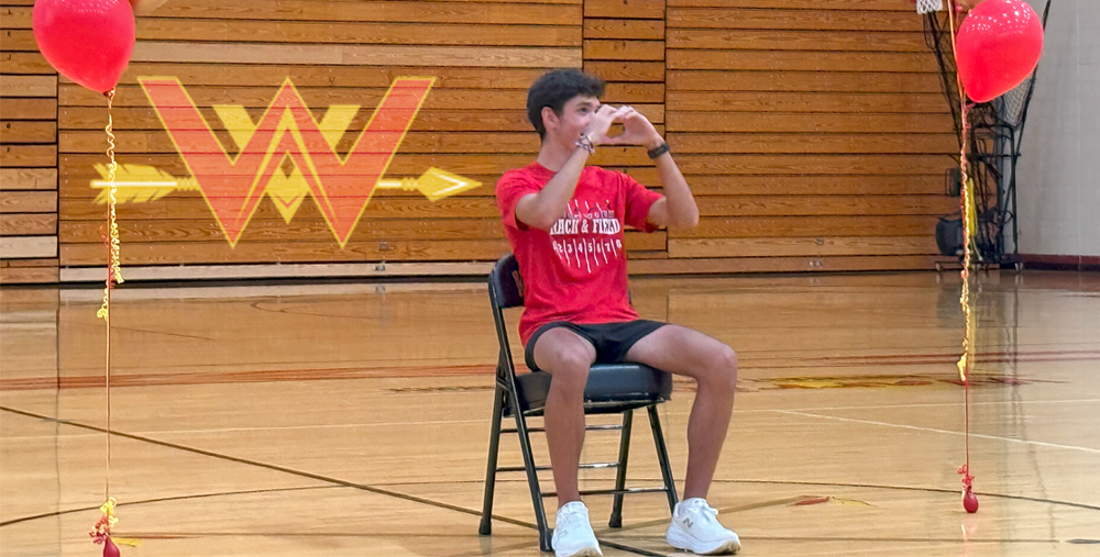 Noah Bontrager holds up heart to the audience cheering him on