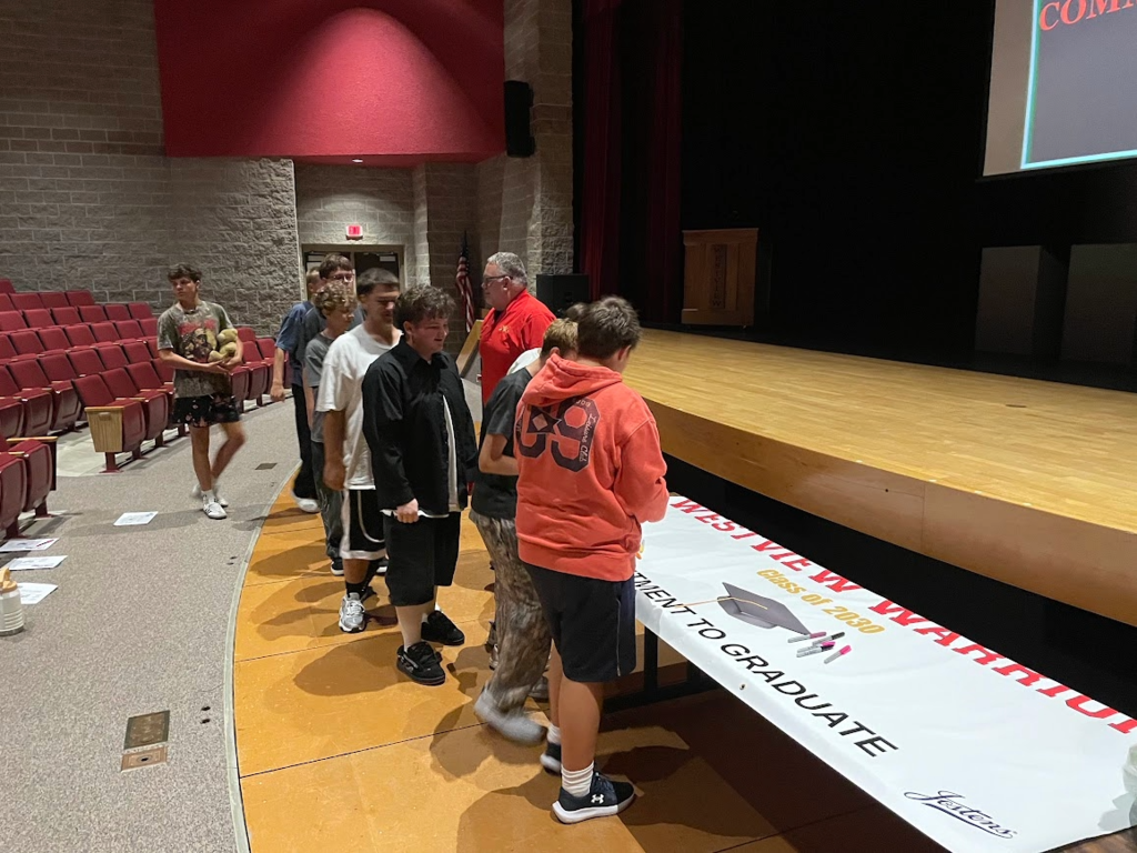 Class of 2030 students signing their graduation banner