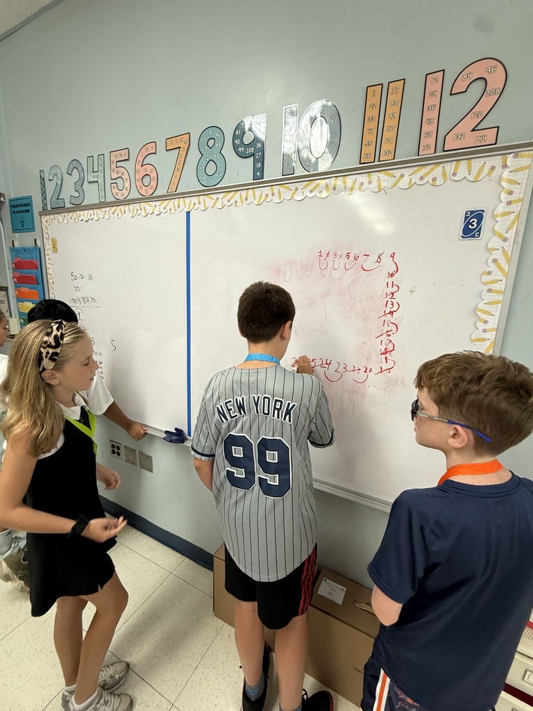 Three students working on a smart board