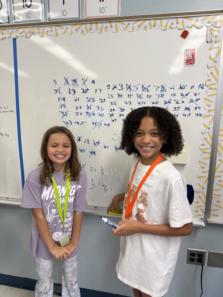 two girls in front of a white board