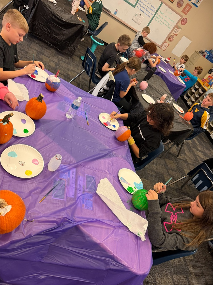Students painting pumpkins. 