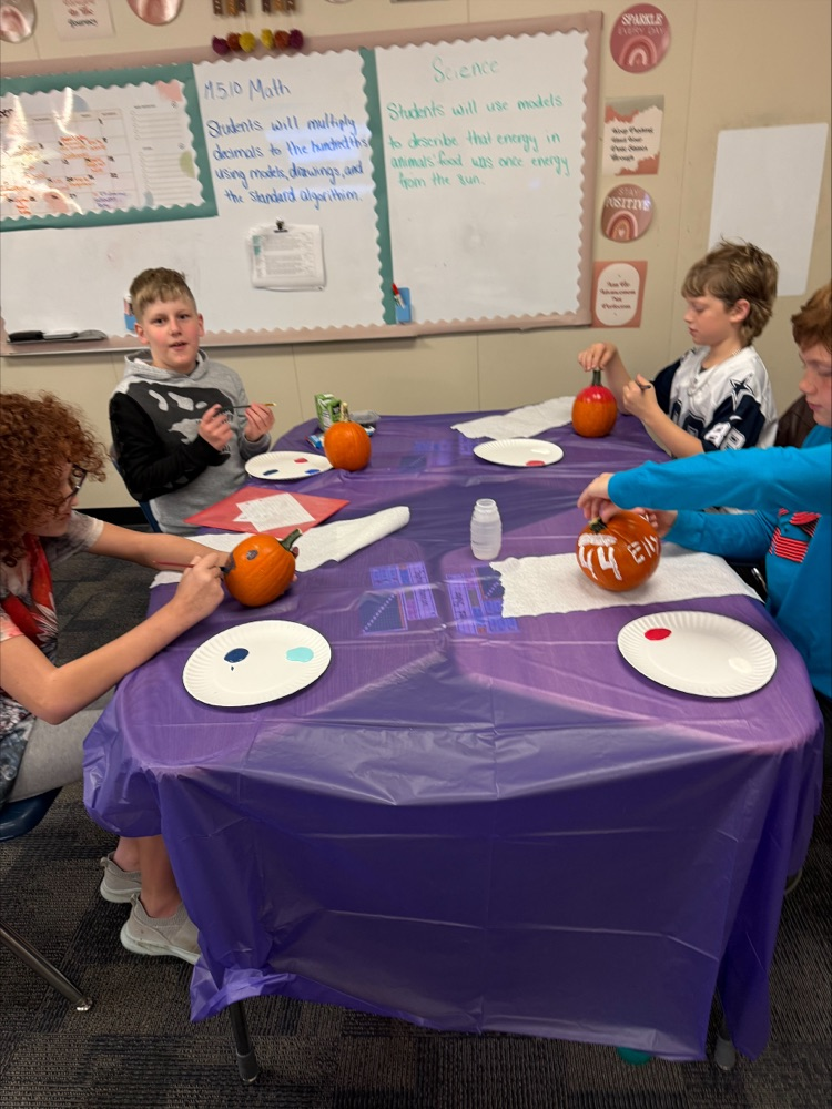 Students painting pumpkins. 