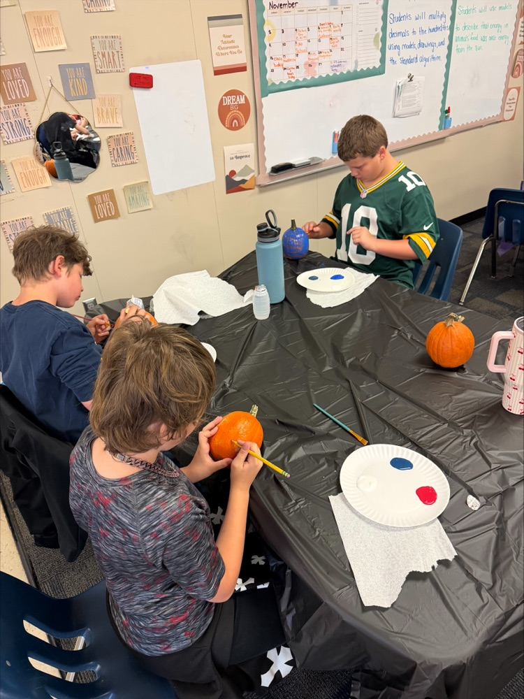 Students painting pumpkins. 
