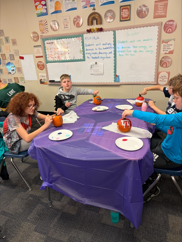 Students painting pumpkins. 