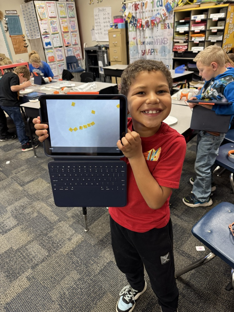 student in red shirt holding a laptop 