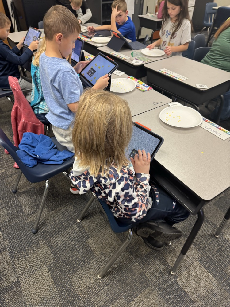 6 students with their iPads at their desks 