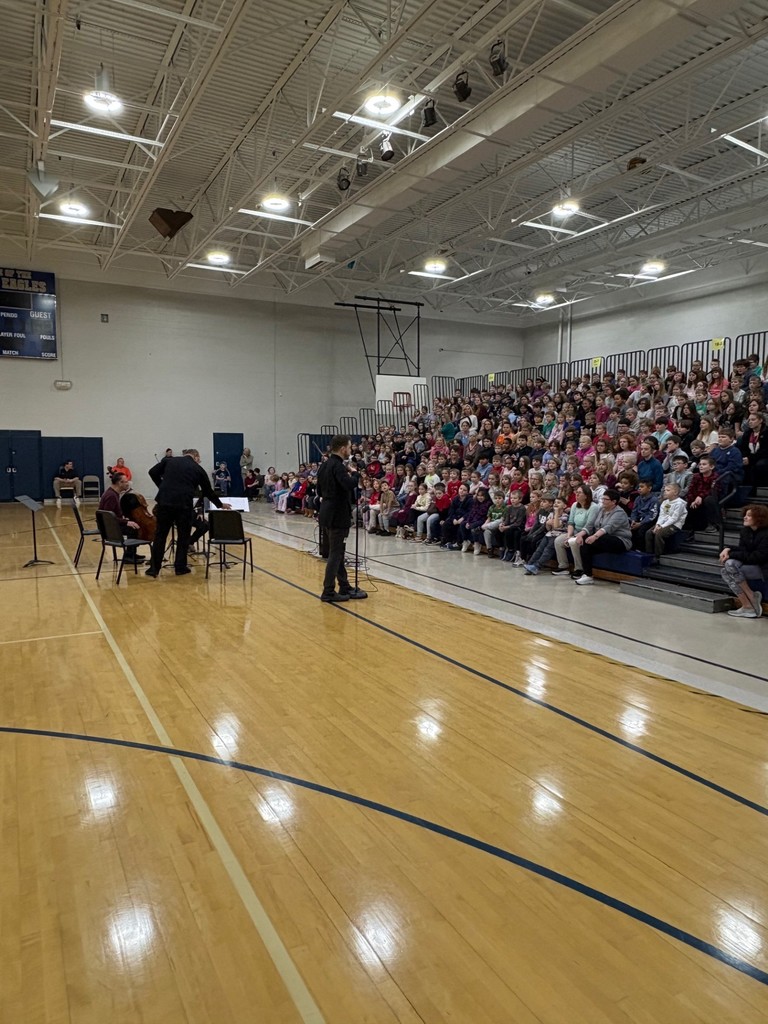 quartet playing in front of students in gymnasium