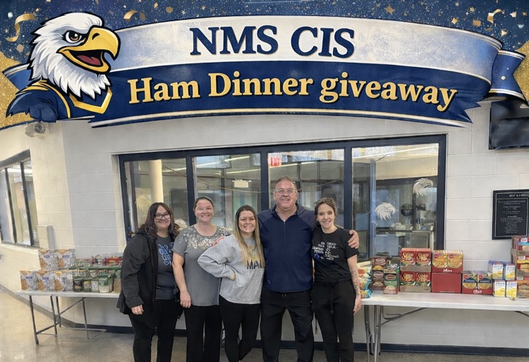man and three women standing in front of ham dinner supplies 