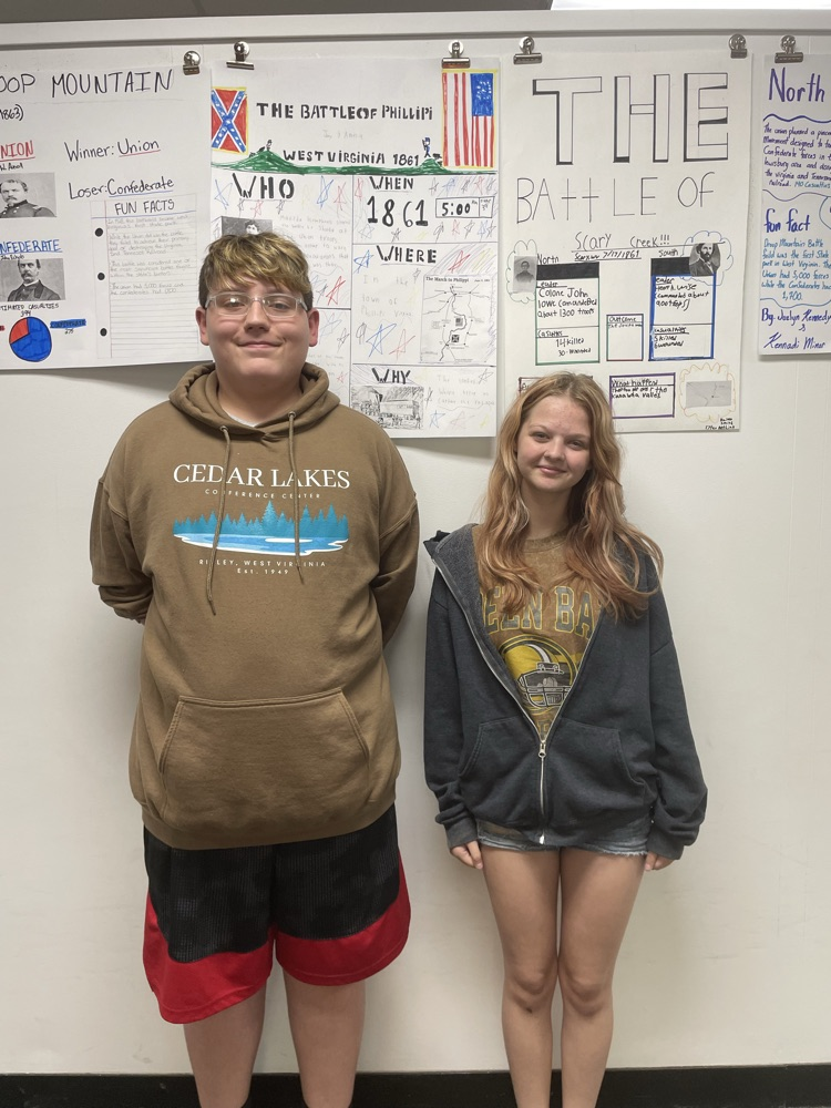 one boy and one girl standing along wall