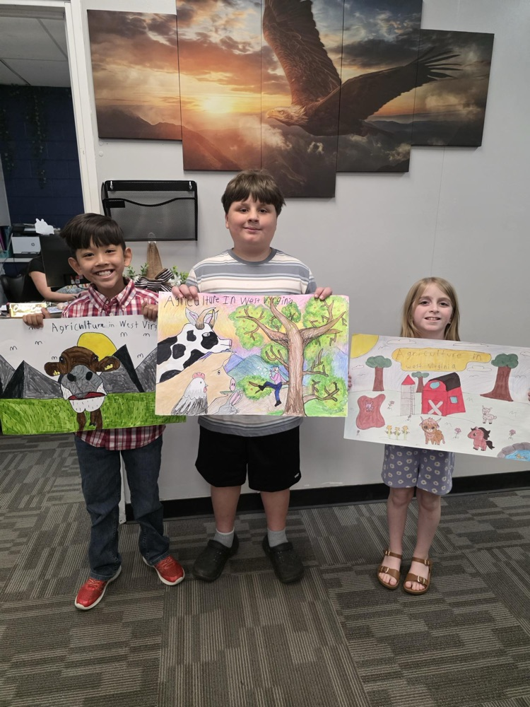 three students holding agriculture posters