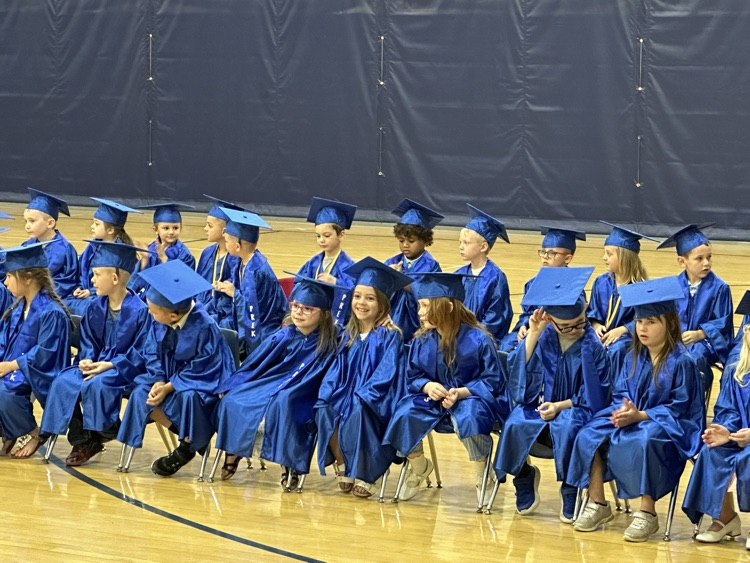 a group of preschoolers in blue gowns 
