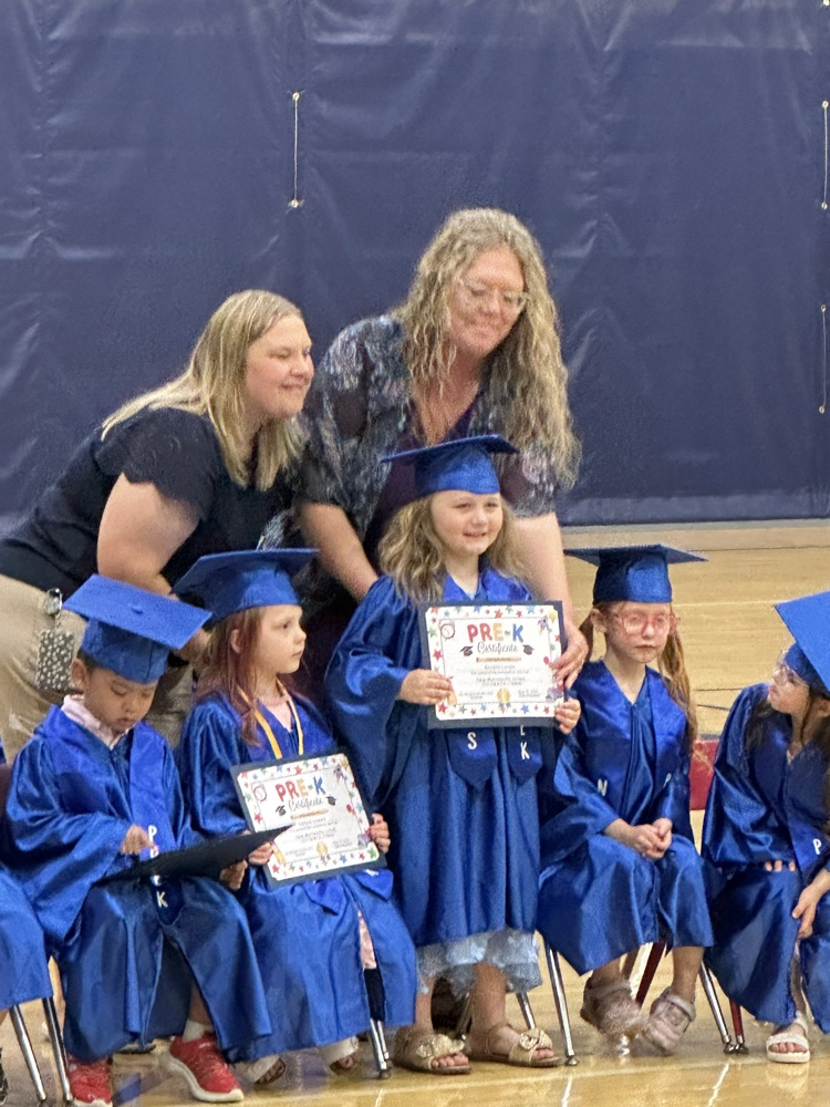 teacher and aide awarding graduate with a certificate