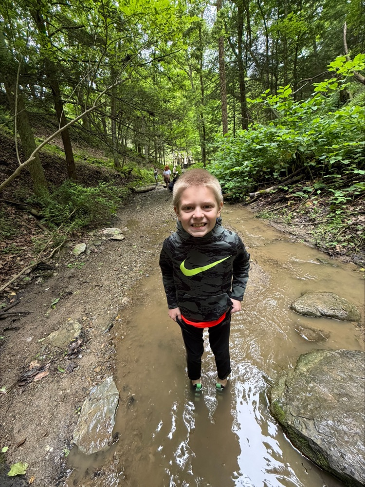 boy with blonde hair standing in the water