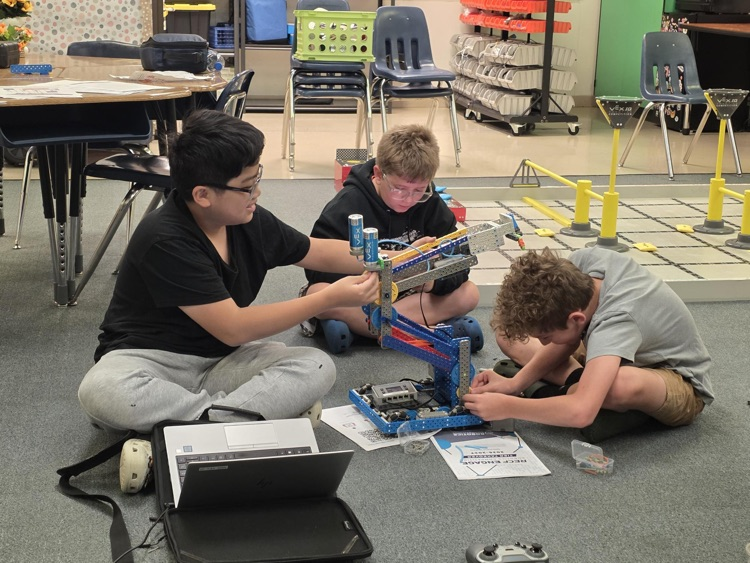 3 students coding robots 