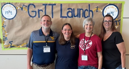 4 teachers in front of bulletin board 