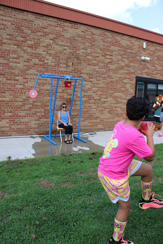 Student throwing ball at bucket dump.
