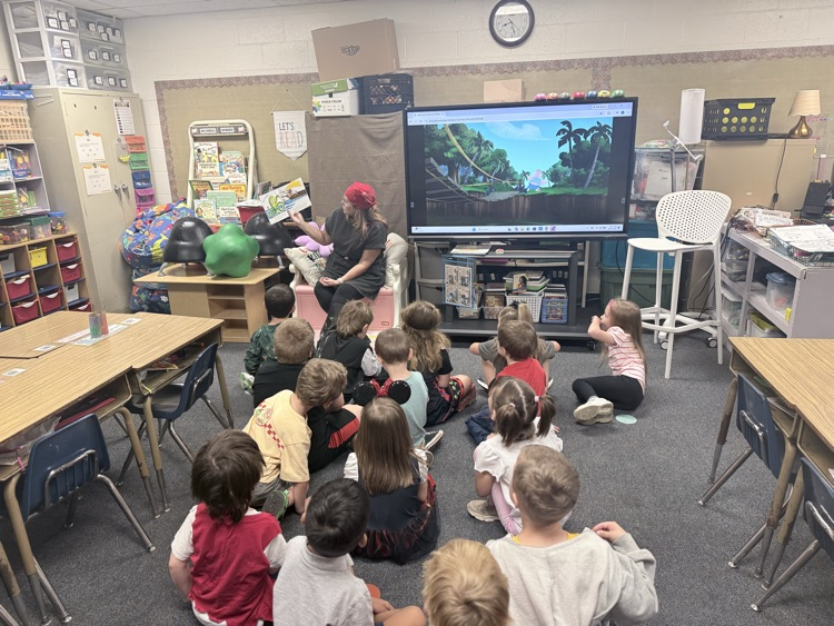 captain reading a book to little pirates on the floor 