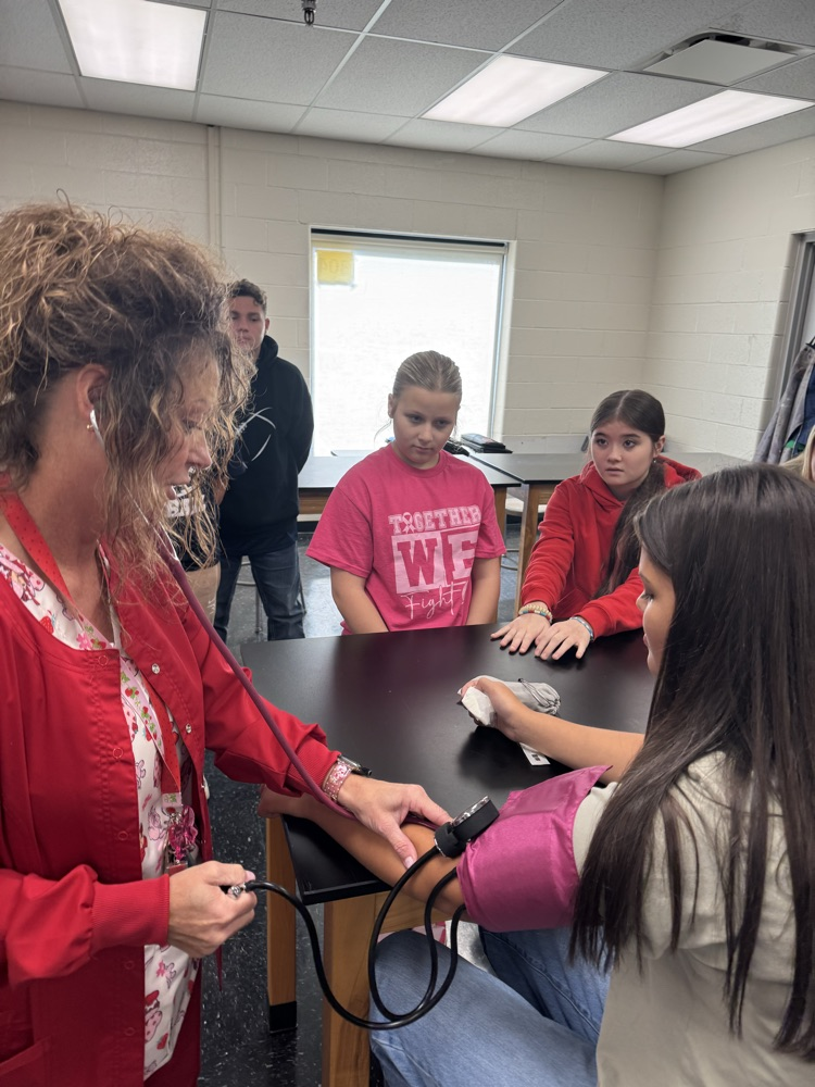 Nurse Long taking a students blood pressure  