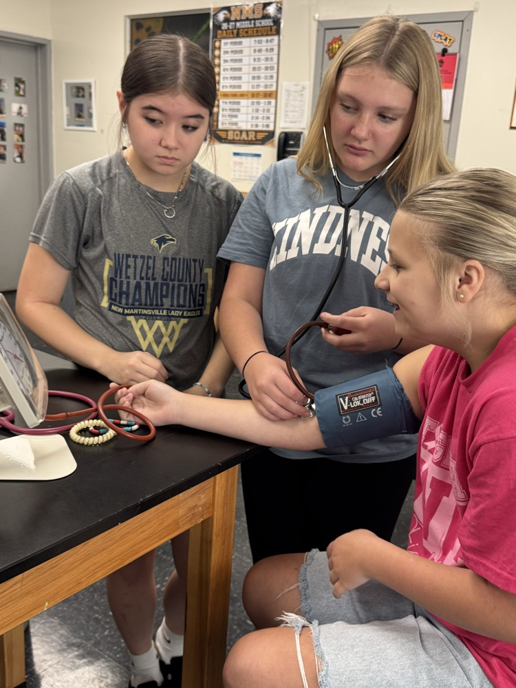 Gigi Frink watches as Brooklynn Williams takes Gracie Bosley’s blood pressure  