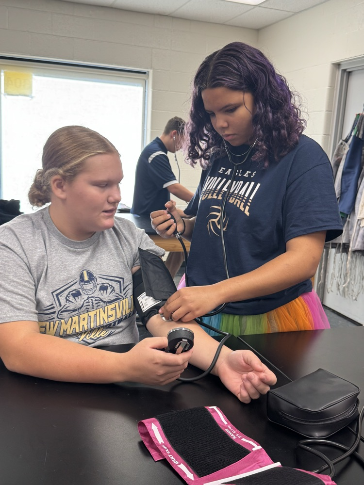 Jasmine Evans taking LexiAnn Taylor’s blood pressure  