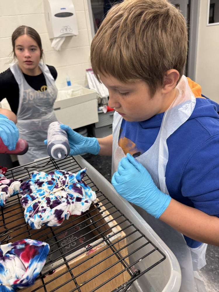 Cash Goddard applying dye to his shirt  
