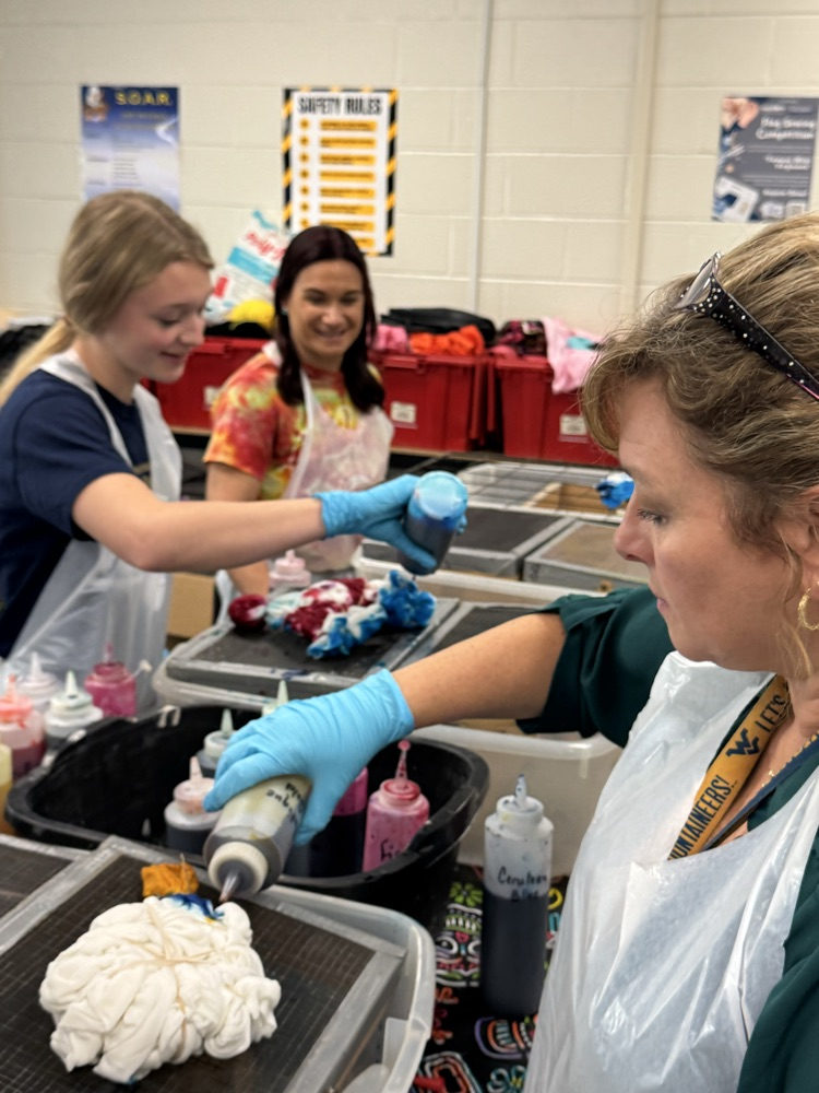 Mrs. Walton and Arah Stoneking apply dye to this shirts while Sarah Seabrook looks on  