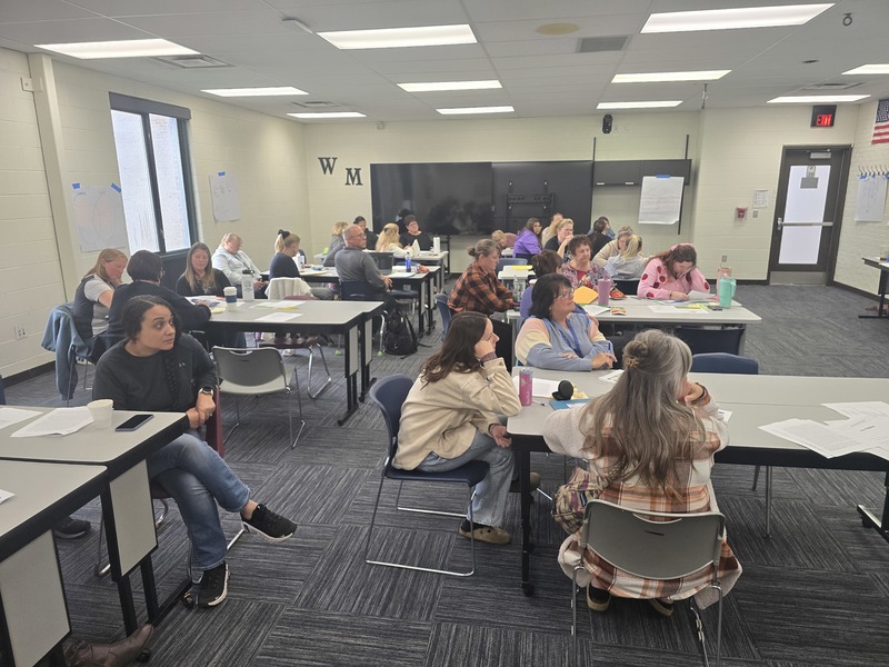 Paraprofessionals listen to a presentation on roles and responsibilities.