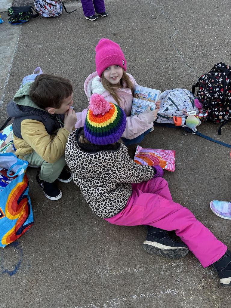 Happy kids enjoying reading outside before school