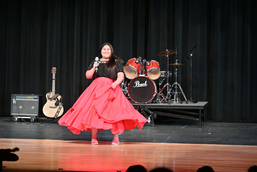 Student standing front and center at concert with microphone 
