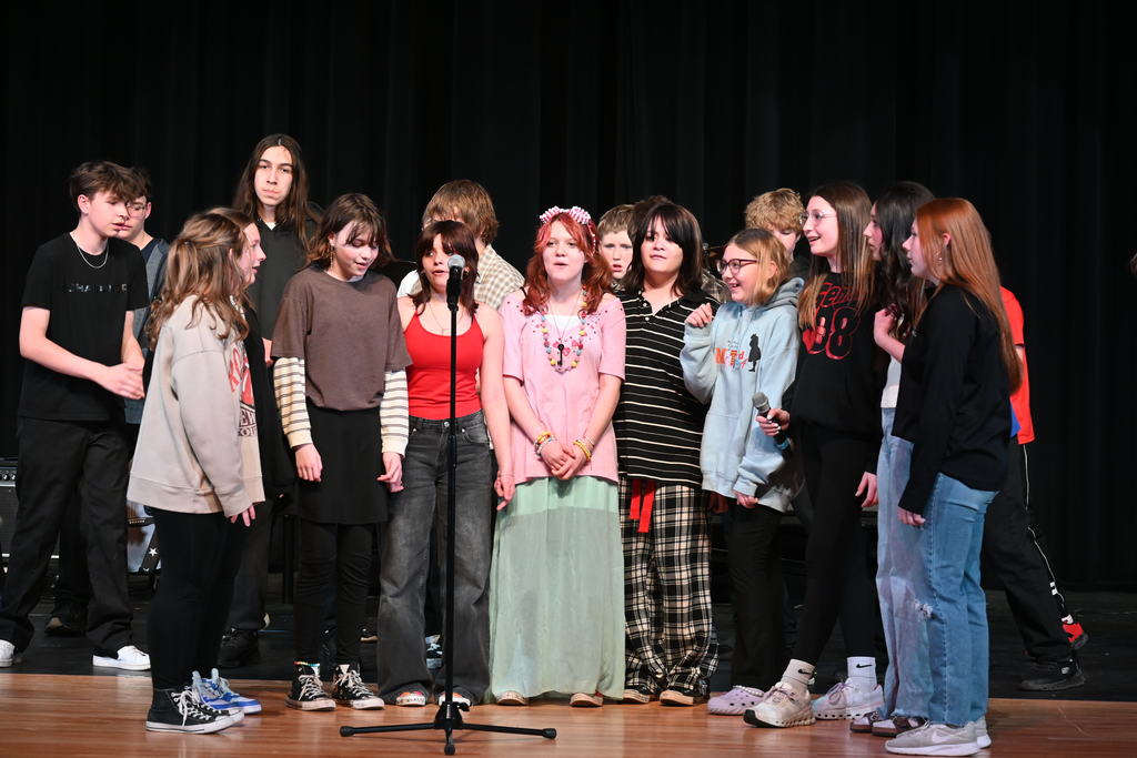 A group of students around a microphone for their part of the concert 